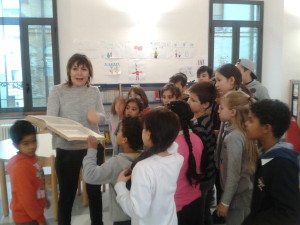 la direttrice Laura Mocchegiani spiega ai bambini come funziona la biblioteca..